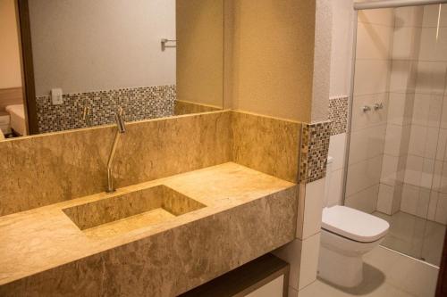 y baño con bañera, aseo y ducha. en Rosa Vilma Hotel, en Chapadão do Sul