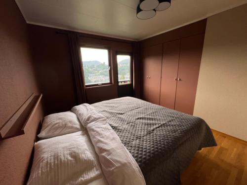 a bedroom with a bed with a window in it at Feriehus i Flekkefjord med panoramautsikt in Flekkefjord