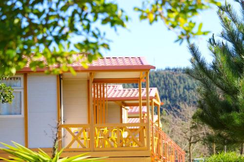 a small house with a porch with a deck at Coimbra Camping & Bungalows in Coimbra