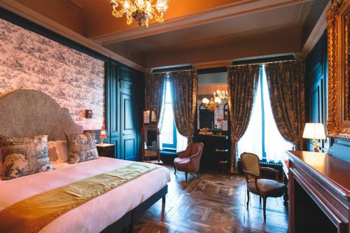 une chambre avec un grand lit et un lustre dans l'établissement Bayard Bellecour, à Lyon