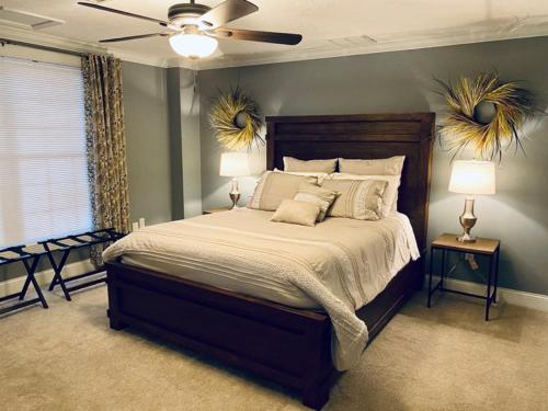 a bedroom with a large bed with two lamps and a fan at Barren Breeze Bed and Breakfast in Lucas
