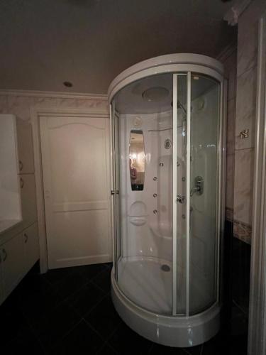 a glass shower in a bathroom with a door at Feriehus i Flekkefjord med panoramautsikt in Flekkefjord