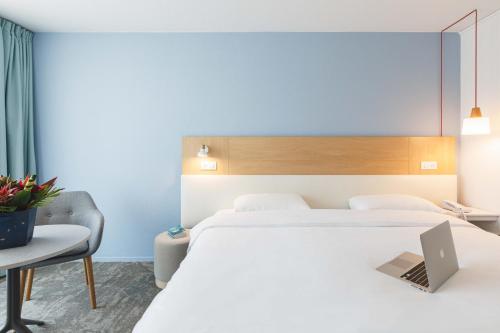 a hotel room with a large bed and a desk at ibis Styles Aix les Bains Domaine de Marlioz in Aix-les-Bains