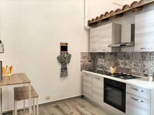 eine Küche mit weißen Schränken und einer Arbeitsplatte in der Unterkunft La tegola in Lecce