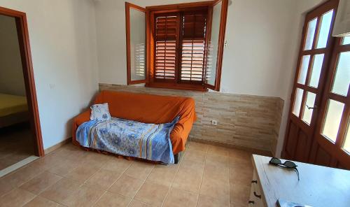 a bedroom with an orange bed in a room with windows at Secluded holiday house Prigradica, Korcula - 19956 in Blato