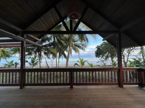 een veranda met uitzicht op de oceaan en palmbomen bij Irana Pacific Hotel in Nuquí