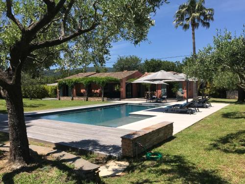 basen w ogrodzie obok domu w obiekcie Villa Beausoleil w mieście Ramatuelle