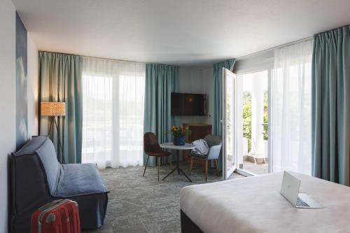 a hotel room with a bed and a table with a laptop at ibis Styles Aix les Bains Domaine de Marlioz in Aix-les-Bains