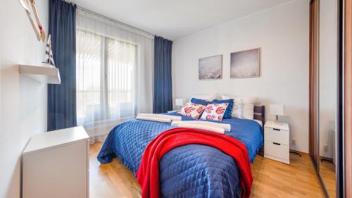 a bedroom with a blue bed with a red blanket at Olympic Park I, Sun & Snow in Kołobrzeg
