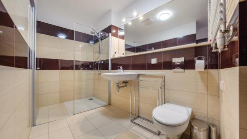 a bathroom with a toilet and a sink and a shower at Olympic Park I, Sun & Snow in Kołobrzeg