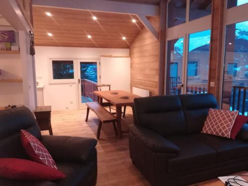 a living room with a couch and a table at Chalet La Plagne Montalbert Pied des Pistes in Aime-La Plagne