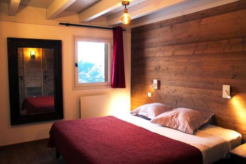艾姆拉普拉涅的住宿－Chalet La Plagne Montalbert Pied des Pistes，一间卧室设有一张大床和一个窗户。