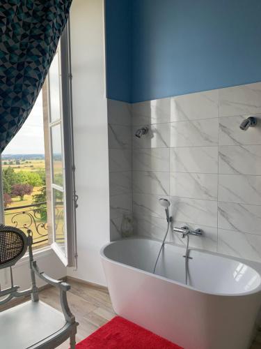 eine weiße Badewanne im Bad mit Fenster in der Unterkunft Château de Briailles - Chambre d'hôtes in Saint-Pourçain-sur-Sioule