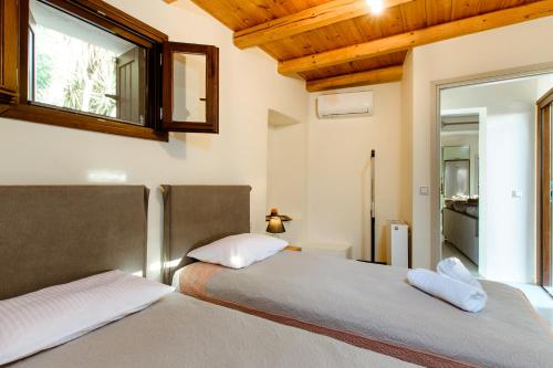 1 dormitorio con 2 camas y espejo en la pared en Nikolas House en Xirokámbion