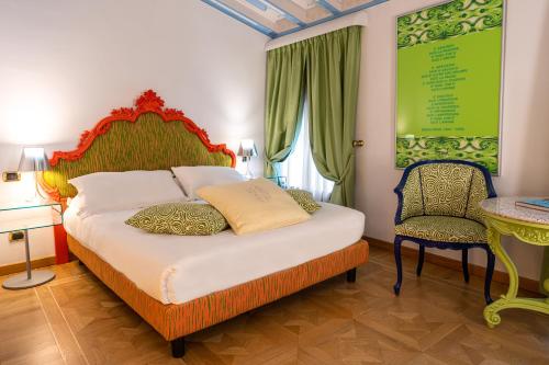 a bedroom with a bed and a table and a chair at Byblos Art Hotel Villa Amistà in San Pietro in Cariano