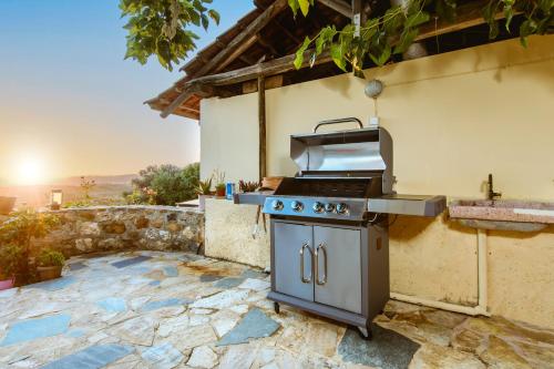 an outdoor kitchen with a grill on a patio at Nikolas House in Xirokámbion