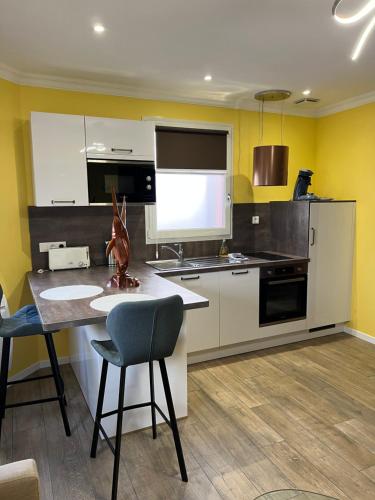 a kitchen with yellow walls and a table and chairs at Plage à 50m Appartement Rêves ensablés Villa Les Bains de Mers in Mers-les-Bains