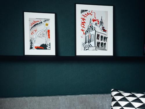 two framed drawings of buildings on a wall at Van der Valk Hotel Schiedam in Schiedam