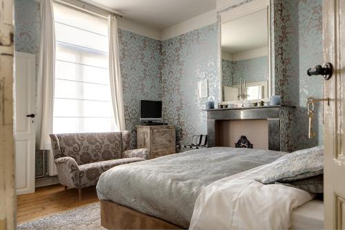 - une chambre avec un lit, un canapé et une cheminée dans l'établissement B&B In Bruges, à Bruges