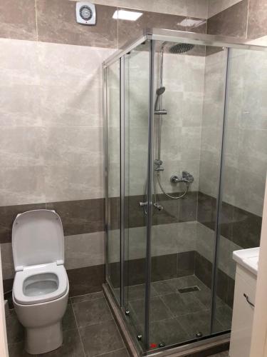 a bathroom with a toilet and a glass shower at Sumgait Boulevard in Sumqayıt