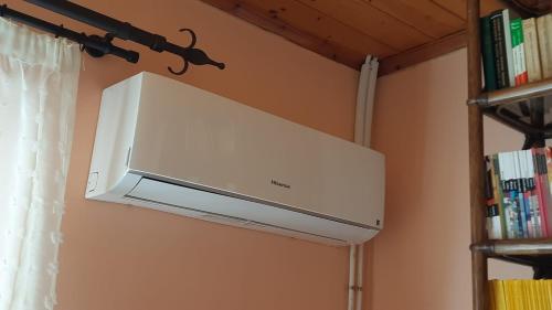 a white microwave hanging from a wall at Ioannis - Zimmer mit Zugang zu Terrasse in Gavrolímni