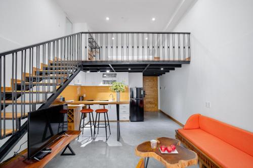 a living room with a orange couch and a table at Flexi Hotel & Apartment Han Market in Da Nang