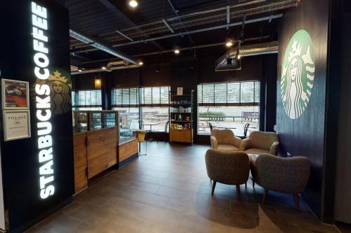 a lobby of a restaurant with chairs and a sign at Village Hotel Aberdeen in Aberdeen
