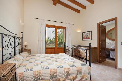 a bedroom with a large bed and a bathroom at Ubac Pollença in Sa Pobla