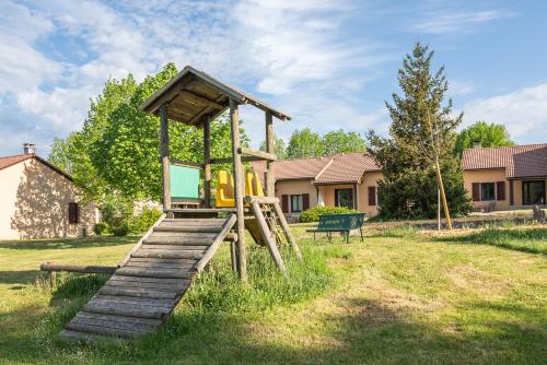 a wooden playground with a slide in a yard at Villages de Gîtes Le Pigeonnier in Le Malzieu-Ville