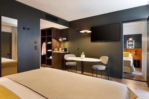 - une chambre avec un lit et une table dans l'établissement RockyPop Grenoble Appartements, à Grenoble