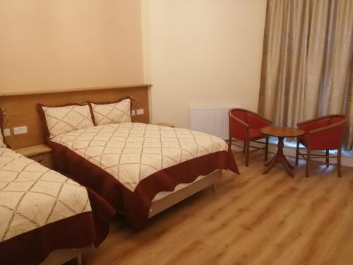 a bedroom with two beds and a table and chairs at Cumberland Hotel in Edinburgh