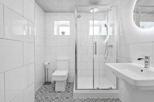 biała łazienka z toaletą i umywalką w obiekcie Coombe Bank - Seaboard spirit, contemporary chic with parking close to beach w mieście Teignmouth