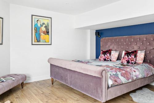um quarto com uma cama grande e uma cabeceira de cama roxa em Coombe Bank - Seaboard spirit, contemporary chic with parking close to beach em Teignmouth