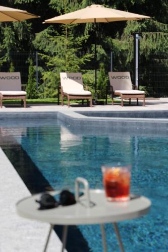 a drink on a table next to a swimming pool at Wood Hotel Resort & SPA in Bukovel