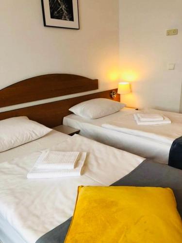 a hotel room with three beds and a lamp at Aqua Hotel in Polkowice