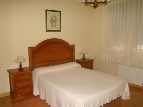 カストロポルにあるApartamentos Peña Marのベッドルーム1室(大型ベッド1台、ナイトスタンド2台付)