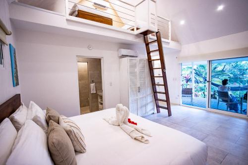Aves Hotel Montezuma في مونتيزوما: غرفة نوم بسرير ابيض مع سلم