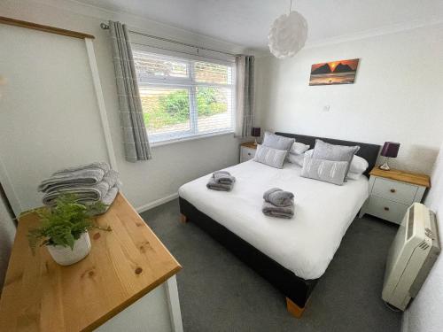 a bedroom with a bed with towels on it at 2 Chatsworth Riverscape Apartments - Peaceful apartment in great location with free parking overlooking the Gannel just a short walk from Newquays incredible beaches and local amenities in Newquay