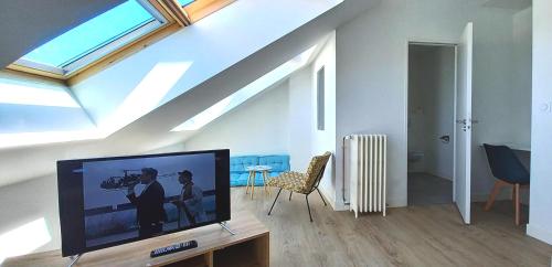 a living room with a flat screen tv on a table at Histoire de Loire La Gabare in Saumur