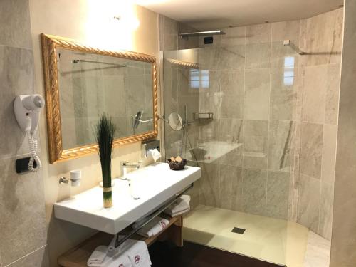 La salle de bains est pourvue d'un lavabo et d'une douche. dans l'établissement Relais du Chateau Blanc, à La Thuile