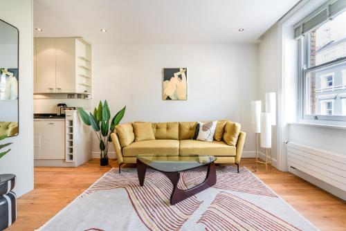 ein Wohnzimmer mit einem Sofa und einem Tisch in der Unterkunft Be London - The Covent Garden Residences in London