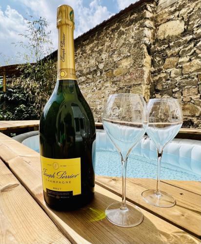 une bouteille de vin et deux verres à vin sur une table dans l'établissement Le jardin d'Eden, à Reims