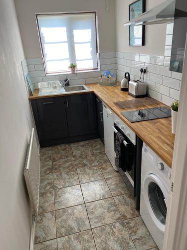 een keuken met een wastafel en een wasmachine bij Lakeside View 2, Perton Village in Wolverhampton