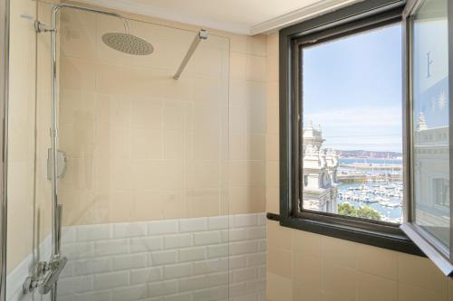 y baño con ducha y ventana. en Hotel Alda Pasaje en Gijón