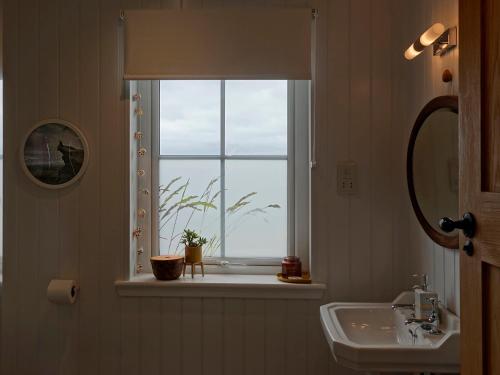 a bathroom with a sink and a window at Hona in Mangersta