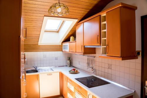 uma cozinha com armários de madeira, um lavatório e uma janela em Kamra15 em Mežica