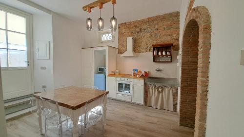 a kitchen with a table and a brick wall at Casina di Alice in Vinci