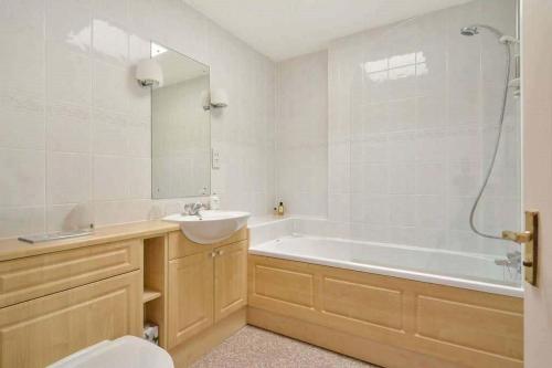 a bathroom with a tub and a sink and a toilet at Links View, Golf Place in St. Andrews