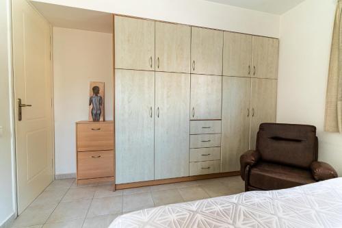 a bedroom with a large cabinet and a chair at Casa d'Arte in Vrahati