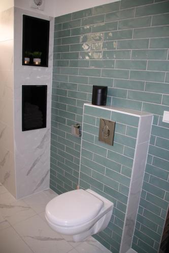 a bathroom with a toilet and a blue tile wall at B&B verDRAAId fijn in Dordrecht